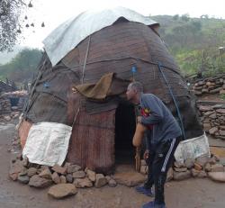 Hamid at a nomad hut with goatskin flask, Djibouti